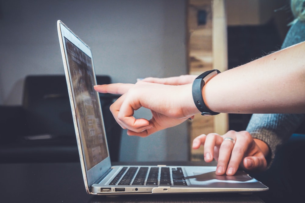 Professional reviewing confidential documents on a laptop at a private desk